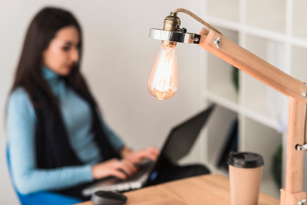 Table lamp near working woman