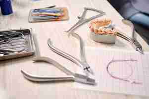 Free photo table with orthodontic instruments ligature ties and teeth model