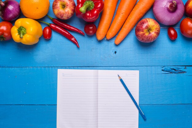 Table with vegetables and a notebook