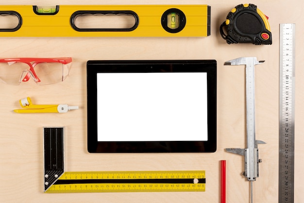 Tablet on architect desk with tools mock-up
