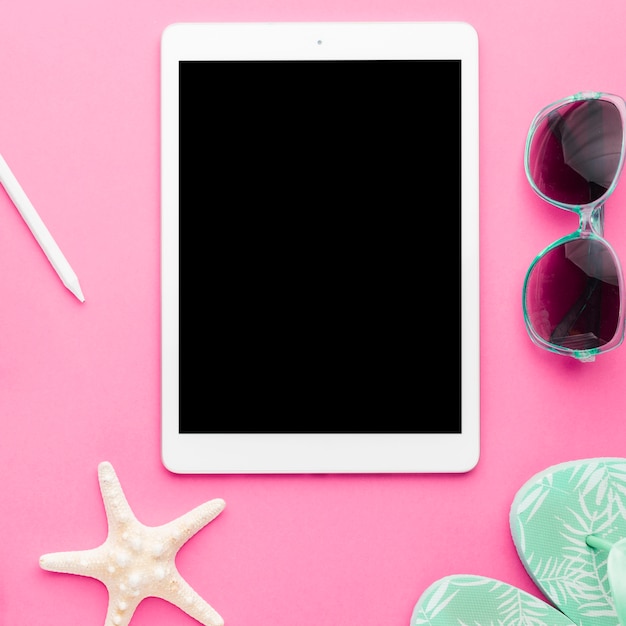 Free photo tablet and beach accessories on bright surface