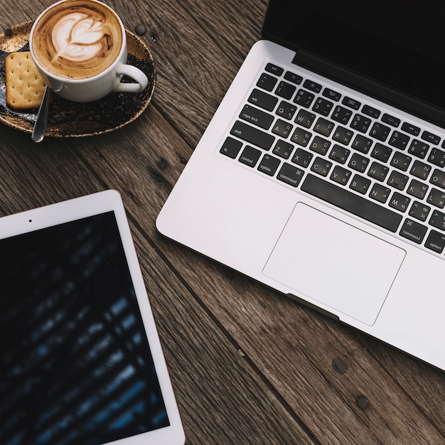 Tablet and coffee near laptop