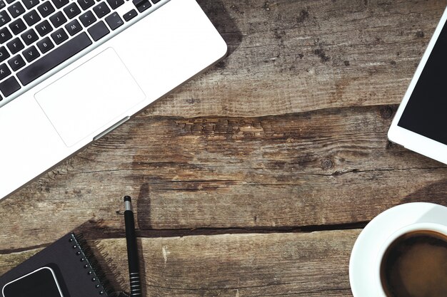 Tablet, computer,smartphone, notepad and pen on the table with a cup of coffee