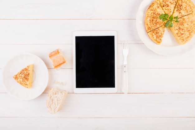 Tablet on kitchen table with cake