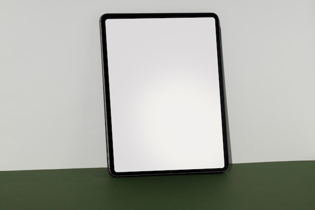 Free photo tablet minimal display on green surface