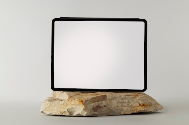 Free photo tablet minimal display on rock