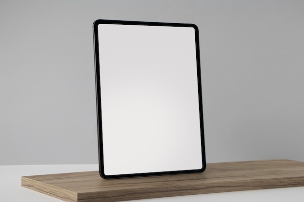 Free photo tablet minimal display on wooden board