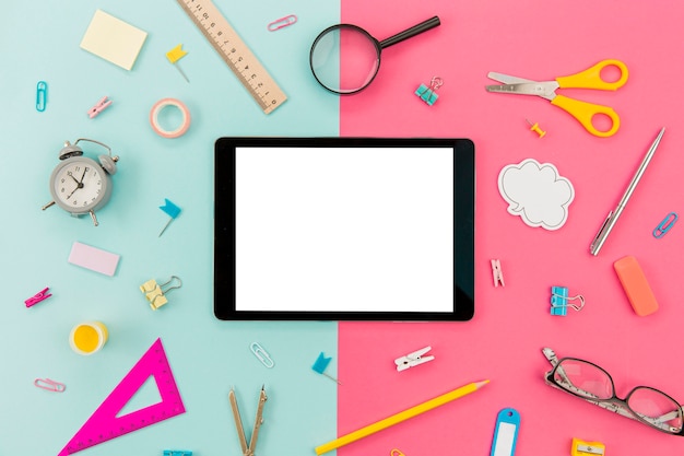 Tablet surrounded by stationery supplies on the table