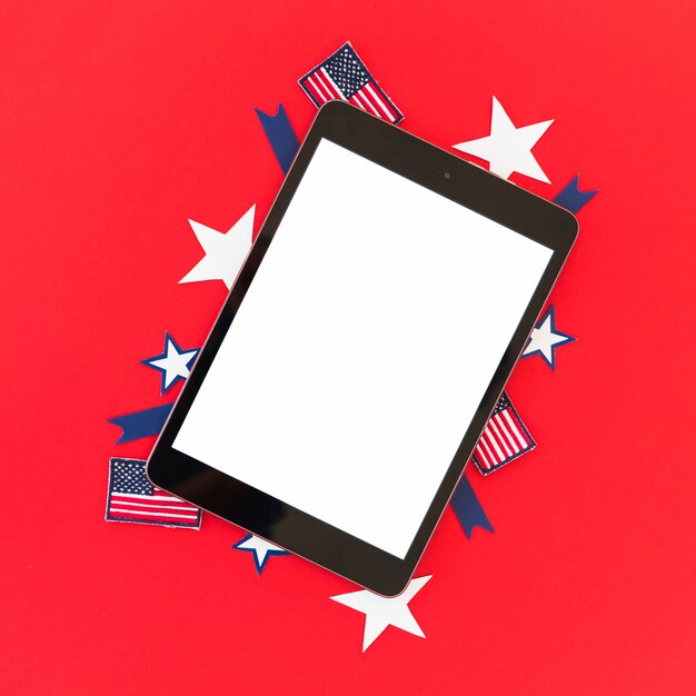 Tablet and symbols of America on red surface
