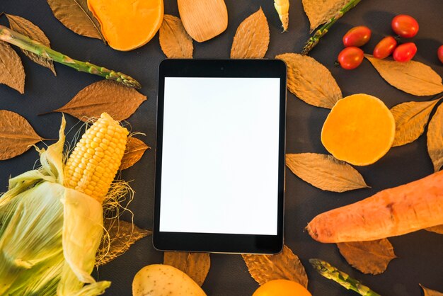 Tablet on table with vegetables 