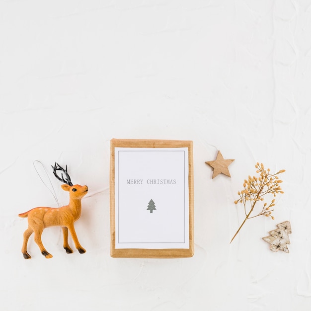 Tablet with paper between decorative fir tree, star and toy deer 