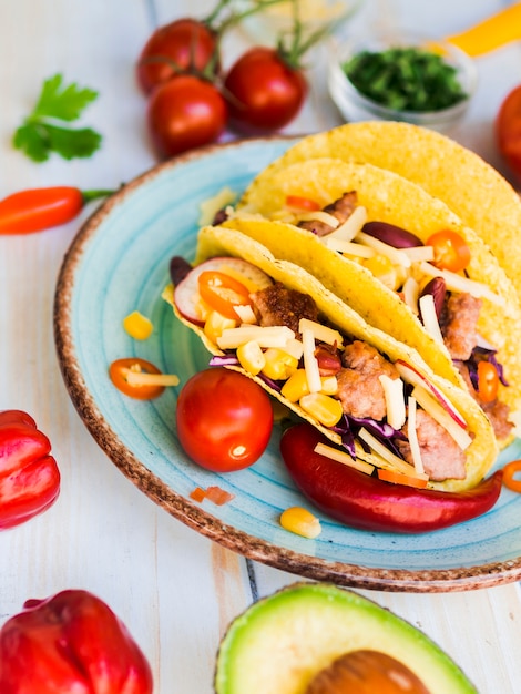 Tacos placed on table near vegetables