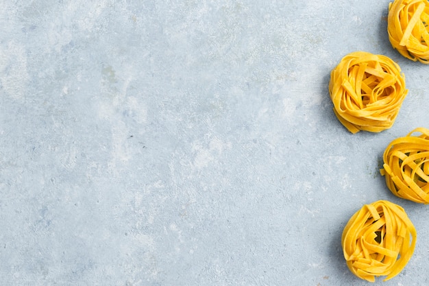 Free photo tagliatelle pasta on textured background