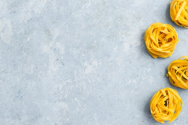 Tagliatelle pasta on textured background