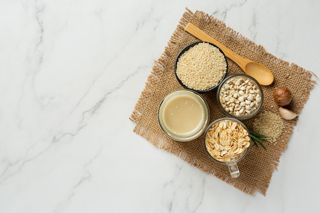 Tahini and sesame seeds on marble background