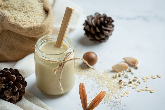 Tahini and sesame seeds on marble background