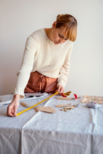 Tailor woman using ruler to measure the fabric