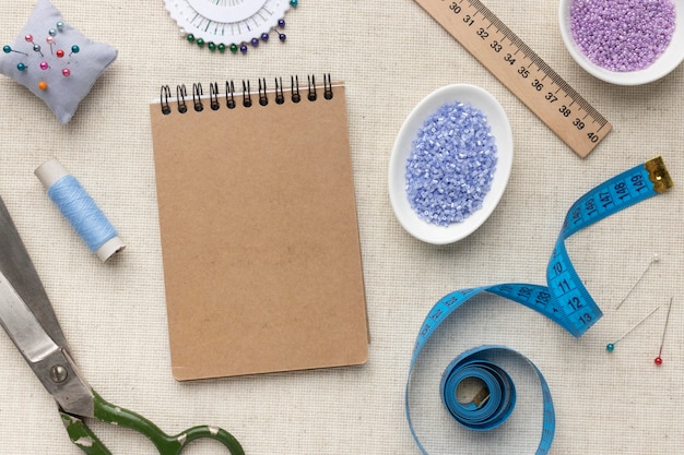 Free photo tailoring tools and elements assortment with empty notepad