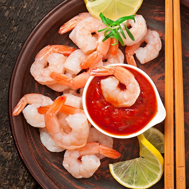 tails of shrimps with fresh lemon and rosemary in plate