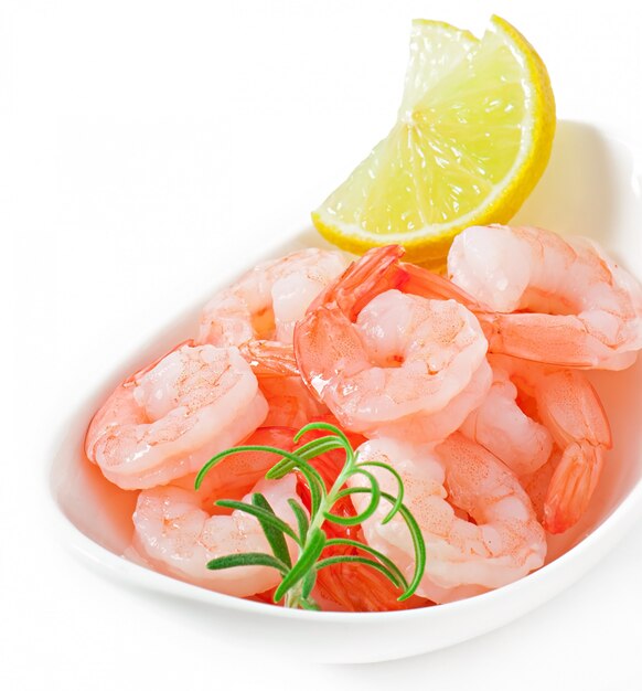 Free photo tails of shrimps with fresh lemon and rosemary in a white bowl