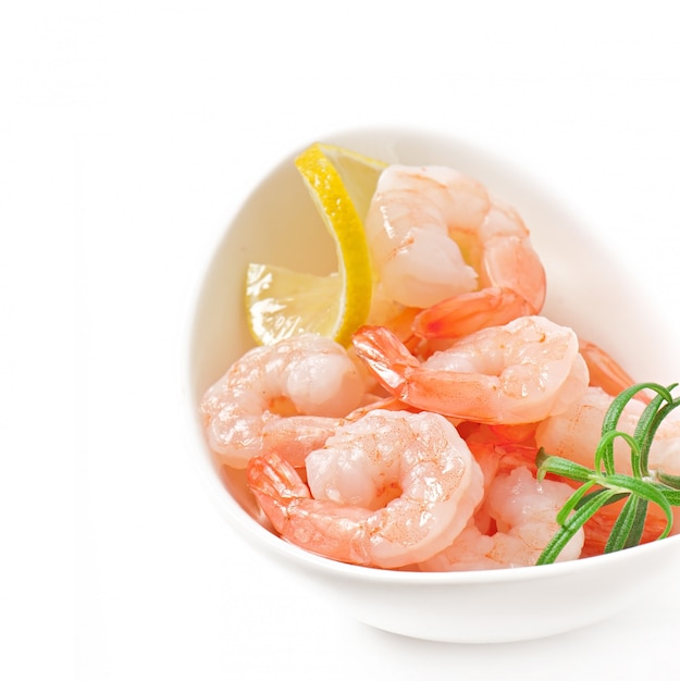 tails of shrimps with fresh lemon and rosemary in a white bowl