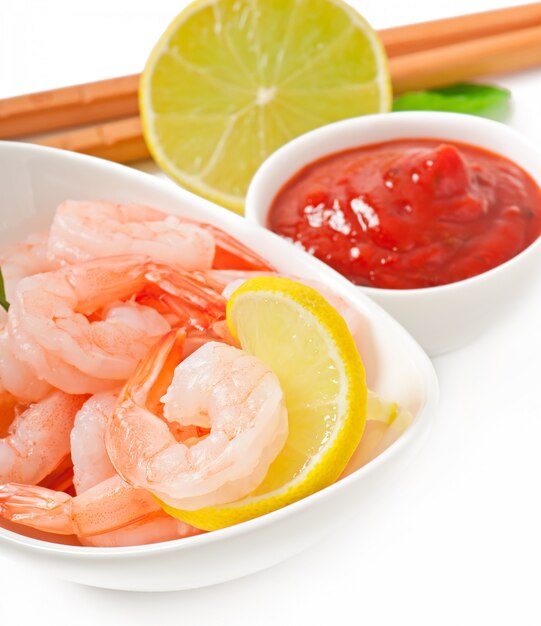 tails of shrimps with fresh lemon and rosemary in a white bowl