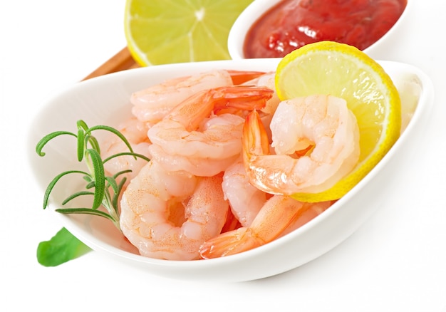 tails of shrimps with fresh lemon and rosemary in a white bowl