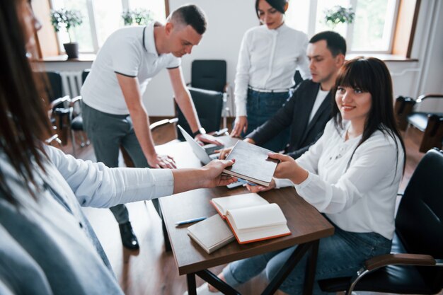 Take this notepad. Business people and manager working on their new project in classroom