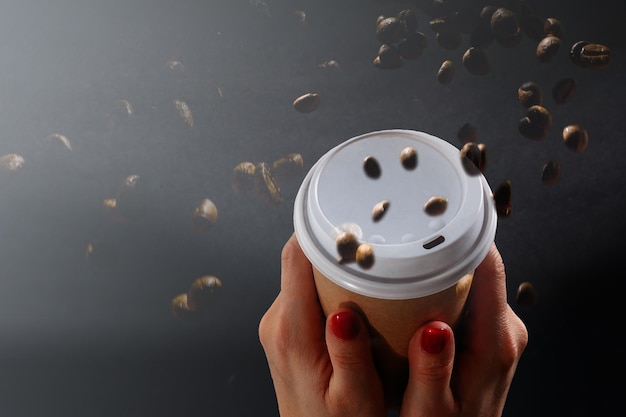 Tazza da asporto con caffè e chicchi di caffè.