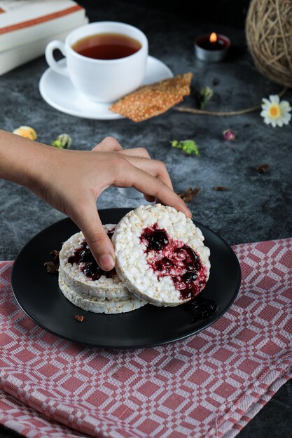 Taking a cracker with red jam