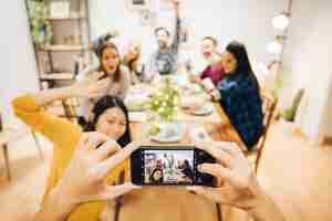 Free photo taking photo of friends sitting at table