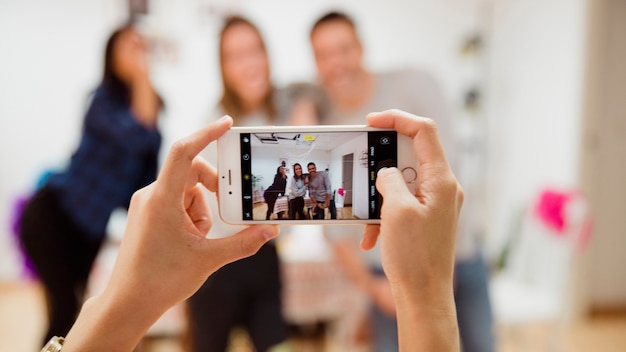 Taking photo of three friends at birthday party