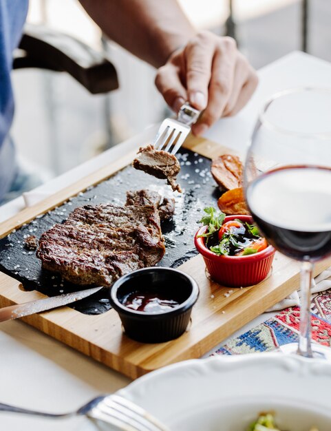 Taking a piece of steak with fork.