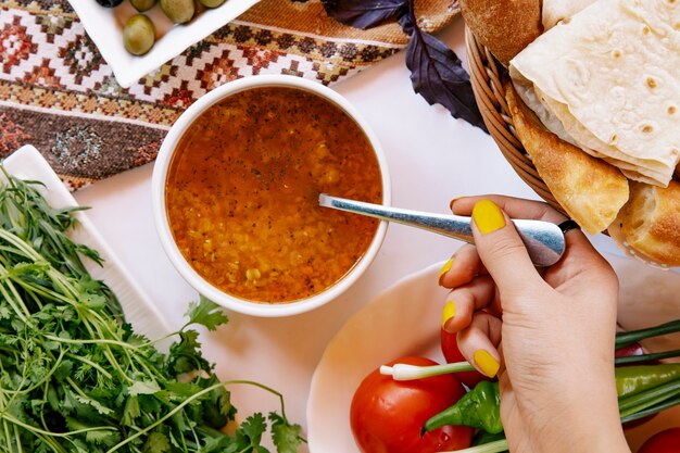 Taking russian borsch soup with a spoon.