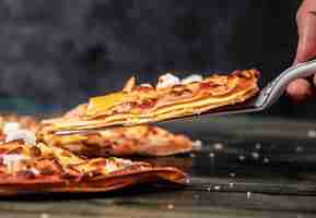 Foto gratuita prendendo una fetta di pizza sul nero