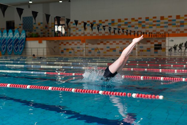 Талантливый спортсмен прыгает в бассейне, полный кадр