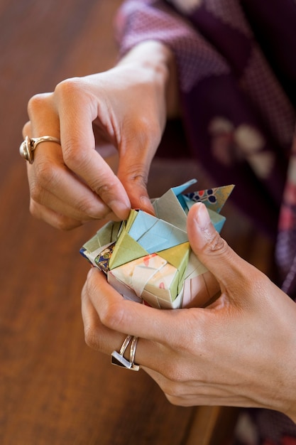 Free photo talented woman making origami with japanese paper