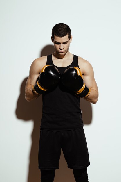 tall attractive sportsman posing in boxing gloves