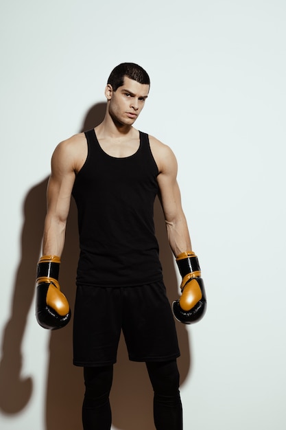 tall attractive sportsman posing in boxing gloves