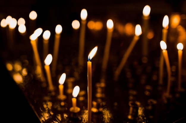 Tall candles shine on the steel dish