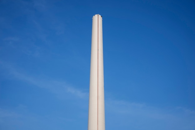 Free photo tall chimney with blue sky low angle