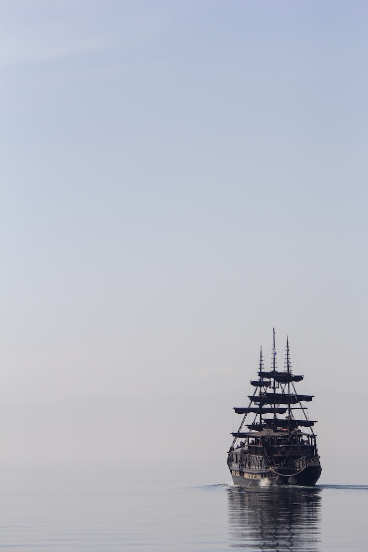 무료 Photo 잔잔한 물에서 항해하는 키 큰 배