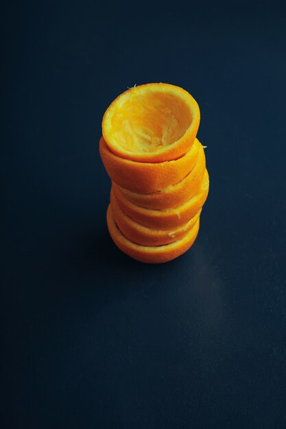 Tangerine peeled cover coats from top view in piramide column shape isolated on old vintage rustic blue table