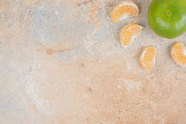 Tangerine and tangerine slices on marble background.