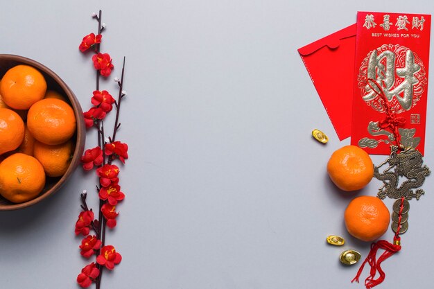 Tangerines and flowers near Chinese decorations