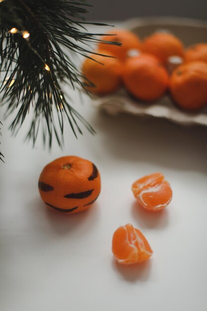 Tangerines with painted stripes on a white background with a christmas tree the concept for the new ...