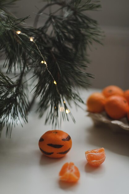 Tangerines with painted stripes on a white background with a christmas tree the concept for the new ...