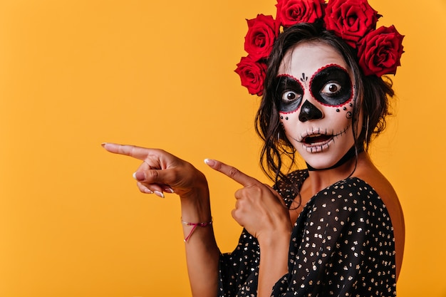 Tanned female model in halloween outfit posing with mouth open. gorgeous girl in traditional mexican attire celebrating day of the dead