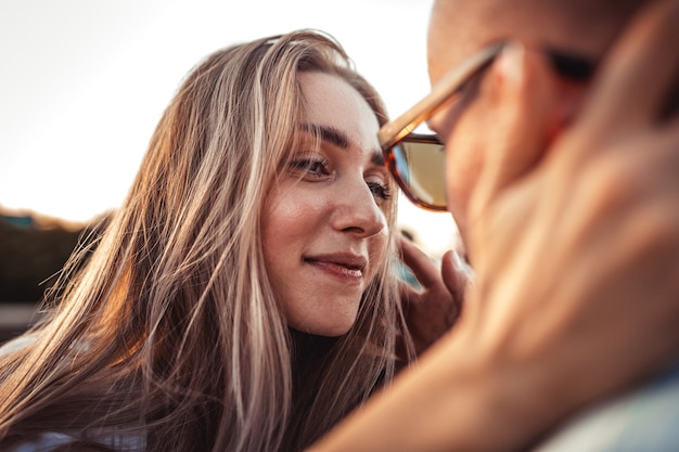 Free photo tanned young caucasian couple, modern lovestory in film grain effect and vintage style. sunset time. walking on the city's street, summer warm evening. honeymoon concept. toned in teal orange.