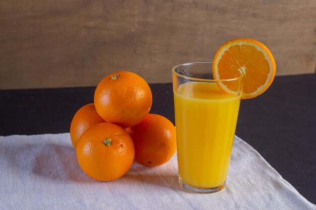 Tarro de cristal con zumo de naranja fresco y fruta fresca sobre una mesa